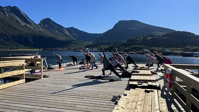 Mennesker gjør yoga på brygge